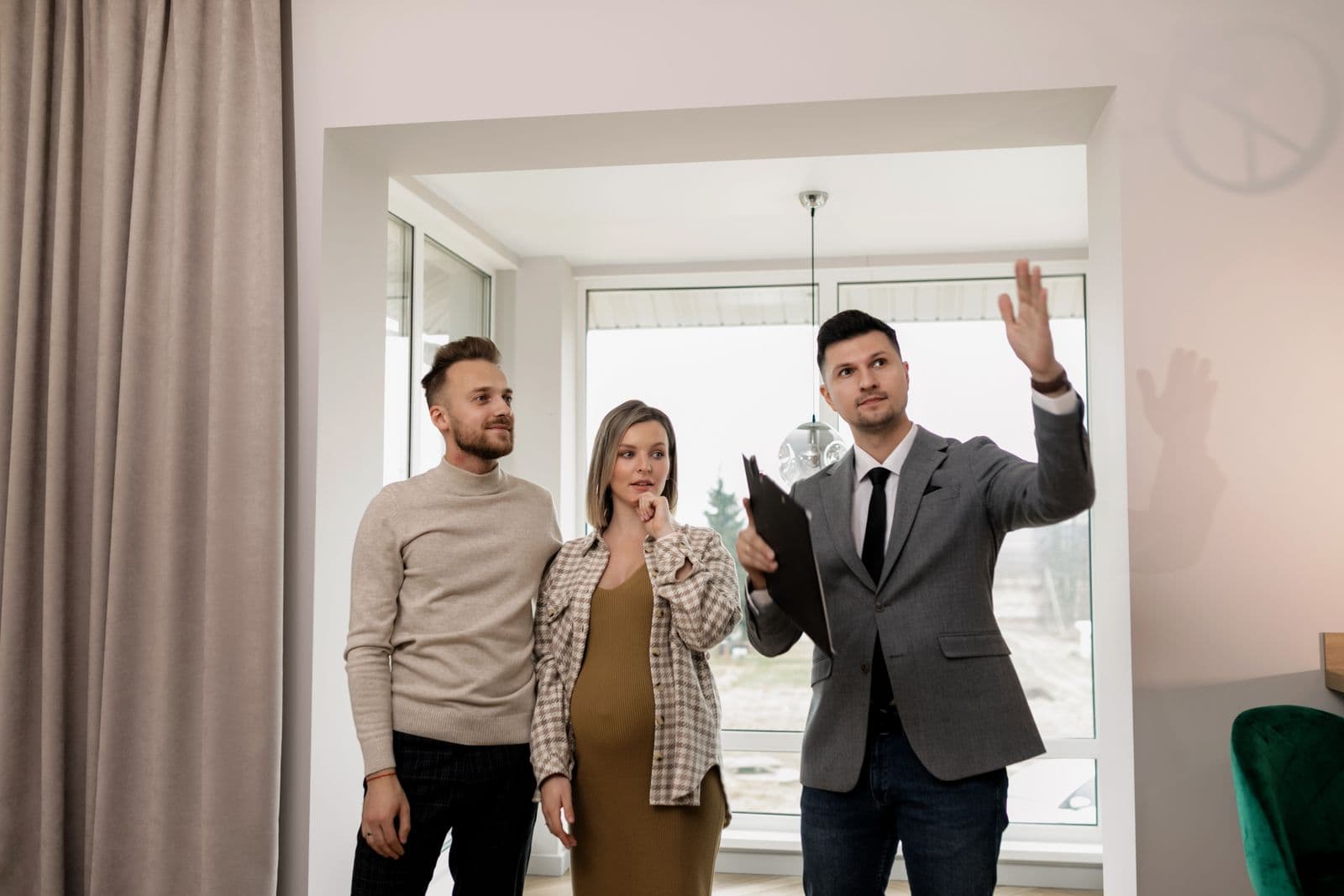 A real estate agent showing a couple through a home